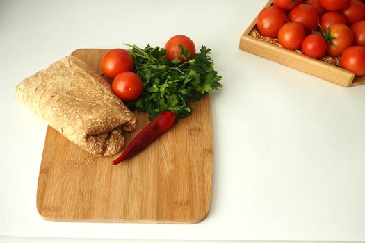 Thin Armenian pita bread with tomatoes greens and spices. ingredients for homemade vegetarian falafel.