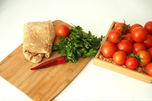 Thin Armenian pita bread with tomatoes greens and spices. ingredients for homemade vegetarian falafel.