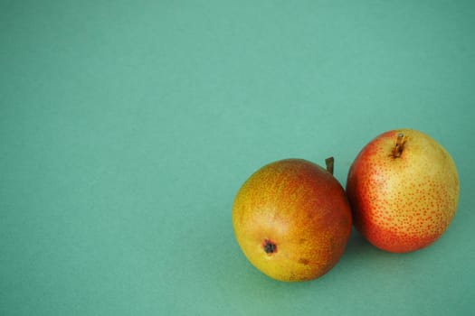 Two ripe pears close up on a green background. Horizontal image. Bright picture.