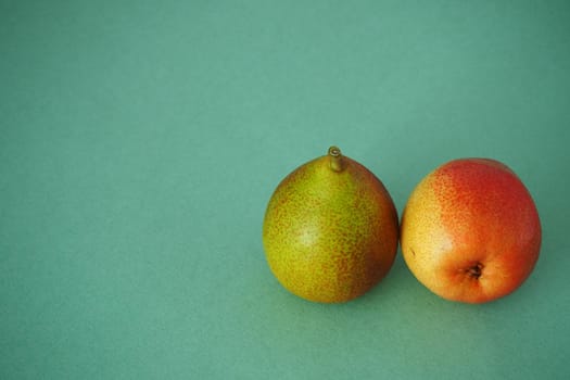 Two ripe pears close up on a green background. Horizontal image. Bright picture.