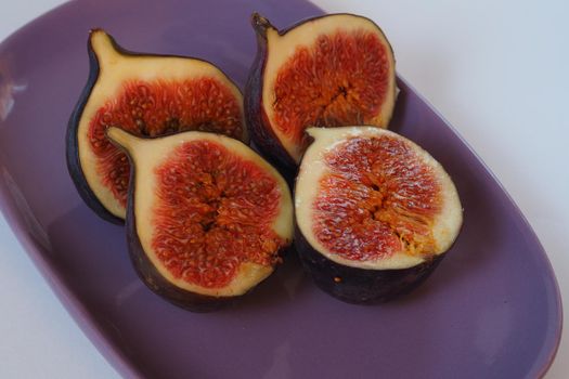 Exotic fruit, ripe purple figs cut on a beautiful plate.