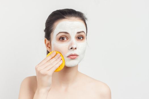 cute brunette with sponges in hands cream mask scrub rejuvenation. High quality photo