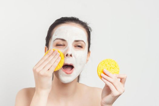 brunette with sponges in hands cream mask scrub. High quality photo