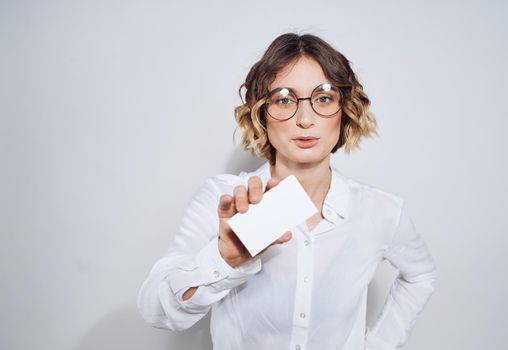 Business woman with a business card on a light background work advertisement. High quality photo