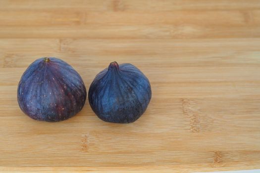 Exotic fruit. Two purple figs on a wooden background, a close-up of high quality photo