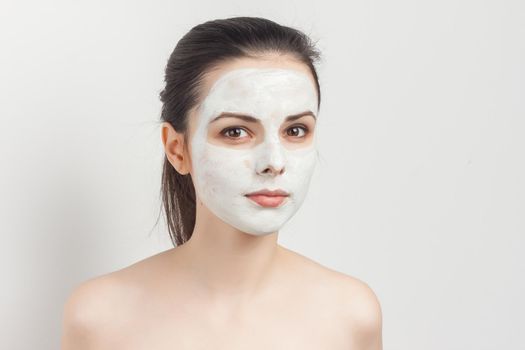 pretty brunette with cream face mask bare shoulders smile cropped view. High quality photo