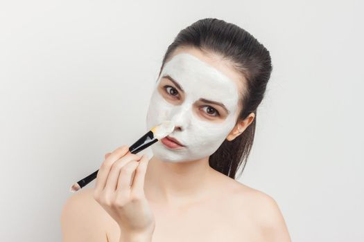 brunette with bare shoulders skin care cream cosmetics hygiene. High quality photo