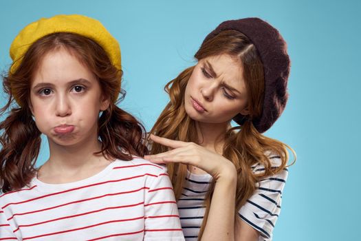 Mom and daughter striped T-shirts hugs fun lifestyle blue background. High quality photo