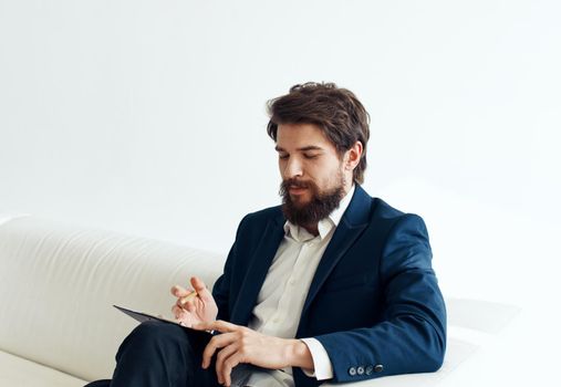 Business man gesturing with his hands in a classic suit Sitting on a sofa indoors. High quality photo