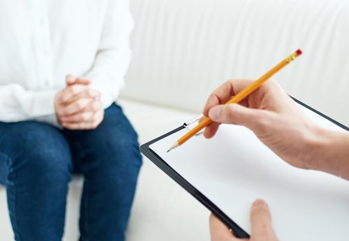 A woman at a psychologist's reception is a white sofa, cropped view. High quality photo
