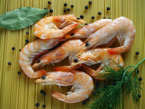 Large prawns with spices and spaghetti. Prawns with dill and pepper close-up. Bright background.