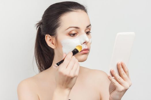 brunette with bare shoulders skin care cream cosmetics hygiene. High quality photo