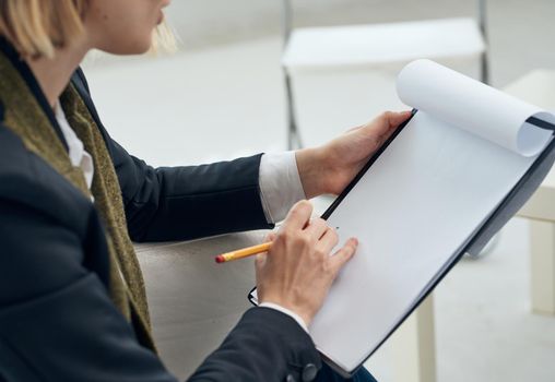 A woman holds a folder with a white sheet of paper in her hands close-up. High quality photo