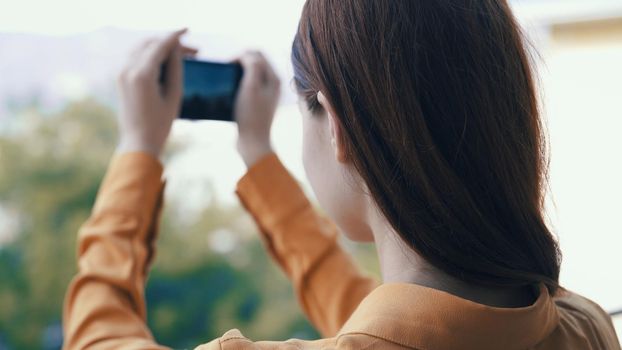 woman outdoors with a phone in her hands takes pictures on camera. High quality photo