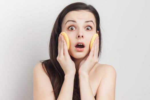 brunette with bare shoulders sponge in hand grooming. High quality photo