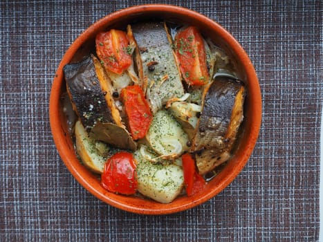 A dish of fish with vegetables baked in the oven. Close-up.