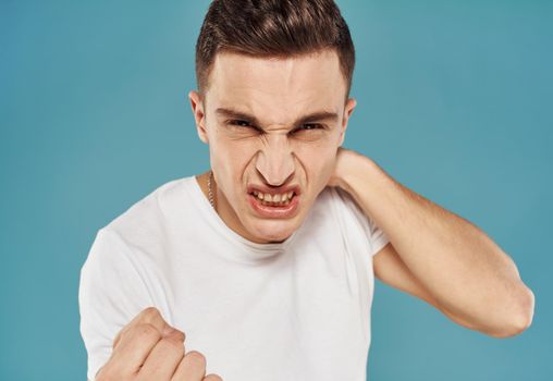 Man in t-shirt emotions gestures with hands displeasure blue background. High quality photo