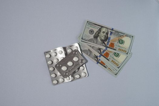 Banknotes, the US dollar, and medicines. The concept of the cost of medicines. High quality photo