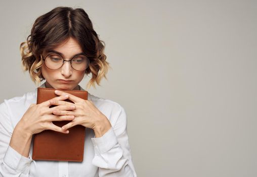 woman on a gray background with a book in her hands and wearing glasses Copy Space. High quality photo