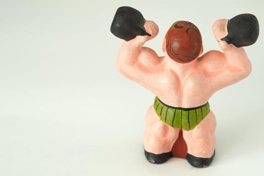 Athlete. The man with the weights. Decorative figurines made of ceramics, plaster and clay. Close-up.