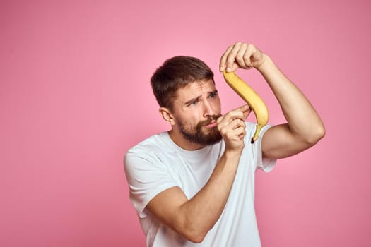 bearded man wearing white t-shirt fruit diet food health pink background. High quality photo