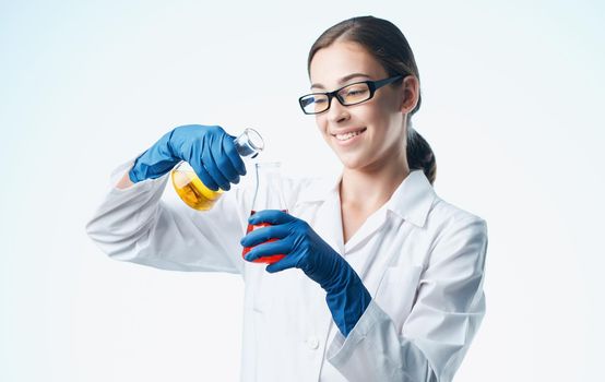 a nurse in a lab coat and blue gloves with a flask in her hand chemical element laboratory analyzes. High quality photo