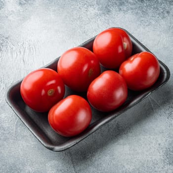 Red ripe tomatoes, on gray background