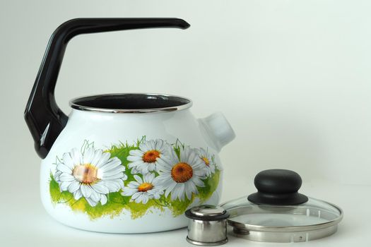 The kettle is an enamelled classic with a whistle. White with daisies. White background,