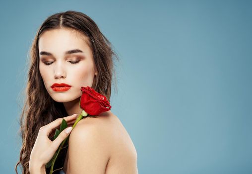 Romantic people with a red rose in their hands on a blue background cropped view. High quality photo