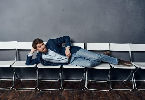 A man lies on chairs waiting for an interview job manager professional. High quality photo