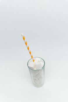 sugar cubes in a glass with a tube high-calorie sweet. High quality photo