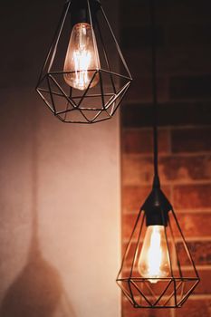 Pendant industrial lamps in loft interior with dark brick walls, modern design and home decor concept