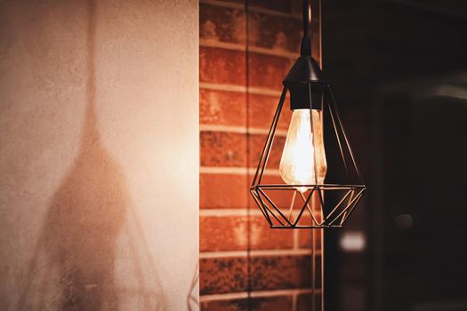 Pendant industrial lamps in loft interior with dark brick walls, modern design and home decor concept