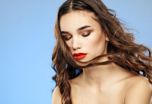 Woman on a dim background with long hair and red lips model makeup. High quality photo