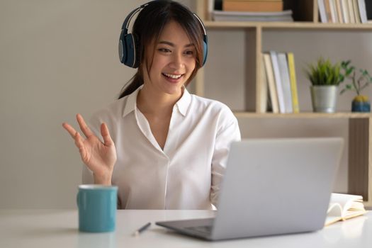 Beautiful asian woman in headphones have video call distant class with teacher using laptop - Online learning concept