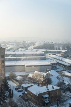 The factory chimneys are smoking during a winter season. The concept of air pollution. Environmental pollution by industrial waste