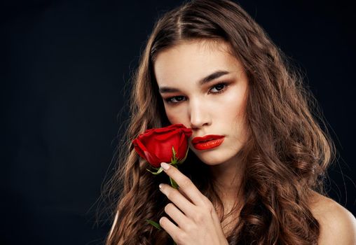 Romantic woman on a black background with a red flower. High quality photo