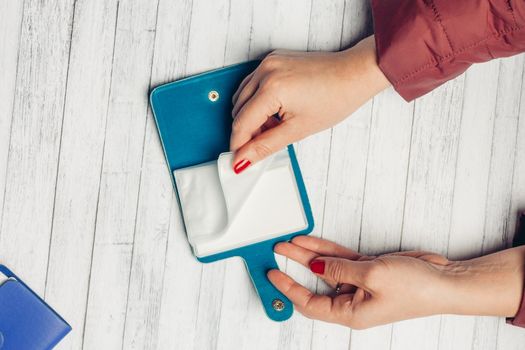 blue business card holder in female hands on a wooden table top view. High quality photo
