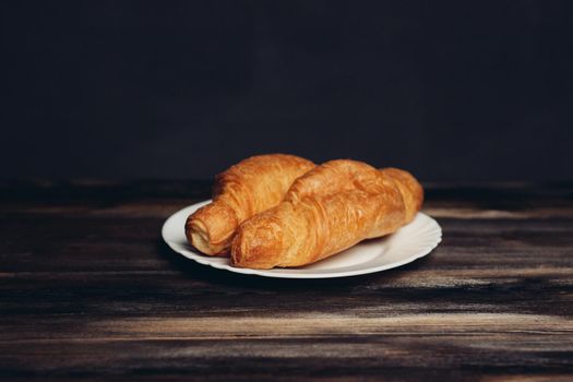 croissants plates wooden table drink mug breakfast dessert. High quality photo