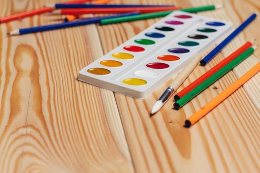 stationery colored pencils paint wooden table. High quality photo