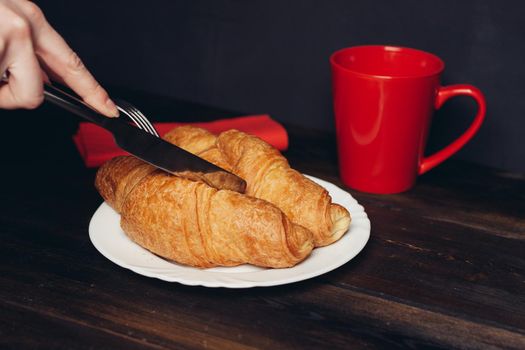 crispy croissants on a plate wooden table coffee mug breakfast. High quality photo
