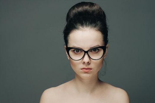 portrait of beautiful brunette woman with bare shoulders fashion hairstyle model cropped view glasses. High quality photo