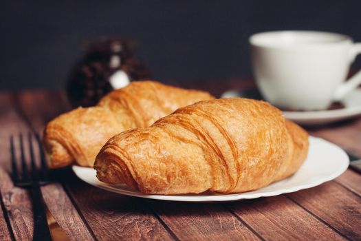 crispy croissants on a plate kitchen utensils for breakfast meal dessert. High quality photo