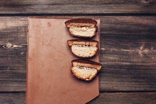 milk chocolate and cake with sweet icing on wooden table top view. High quality photo