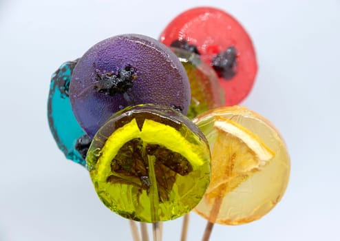 Fruit lollipops with different berries and fruits inside close-up.