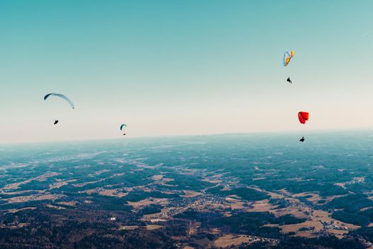 sports paragliding on a parachute over the countryside.