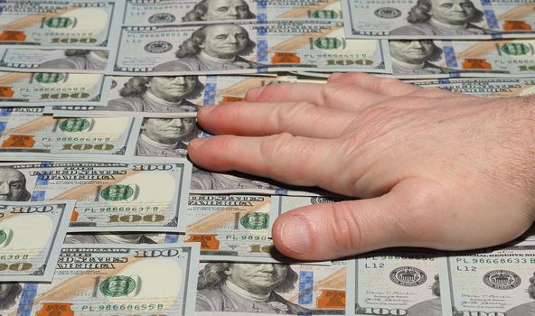 Mens hand against the background of banknotes. American dollar, background. High quality photo