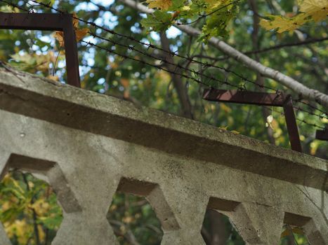 Barbed wire on top of a concrete fence at a protected facility.