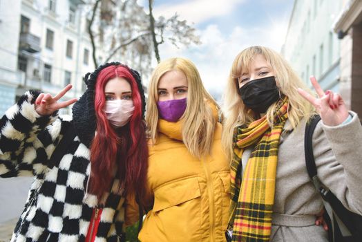portrait of a group of girls with protected wearing masks, making the Two Finger Peace Sign Hand Gesture . Concept of happiness and security at the quarantine time