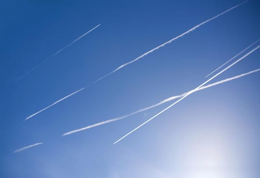 Airplanes in blue sky with Vapor Trail. Condensation trails of planes in the sky. Travel concept.